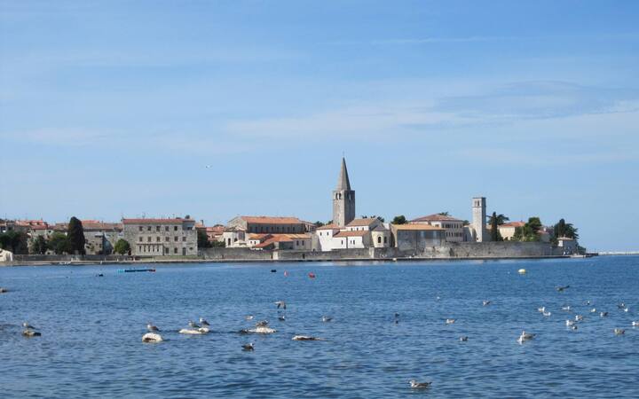 Het oude centrum van Poreč op een landtong in zee, met de klokkentoren van de Euphrasiusbasiliek boven de daken