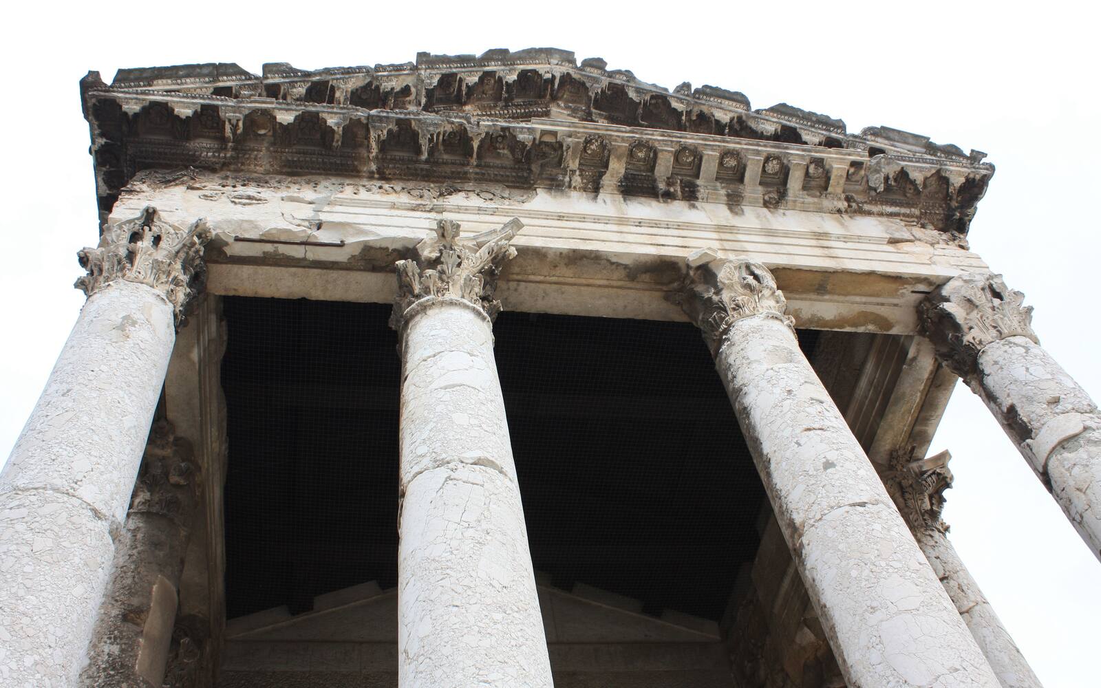 De zuilen en de gevel van de Romeinse tempel van Augustus op het Forum in Pula