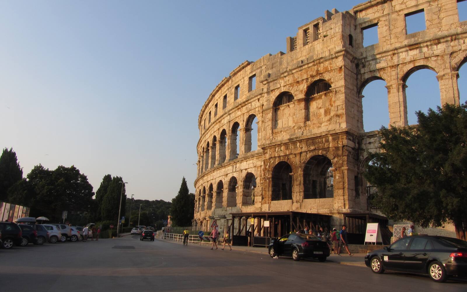De Romeinse arena van Pula met zijn drie verdiepingen stenen bogen, gezien vanaf de straat bij avondlicht