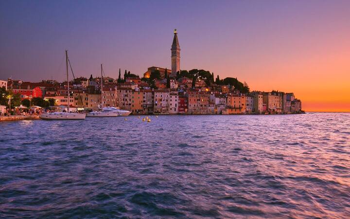 Het oude centrum van Rovinj op een schiereilandje met de klokkentoren van de Sint-Euphemiakerk bij zonsondergang