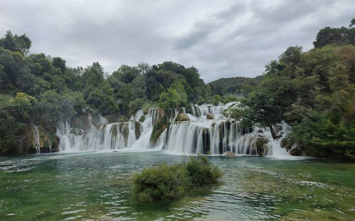 Brede cascade van de waterval Skradinski buk in Nationaal Park Krka tussen groene bomen