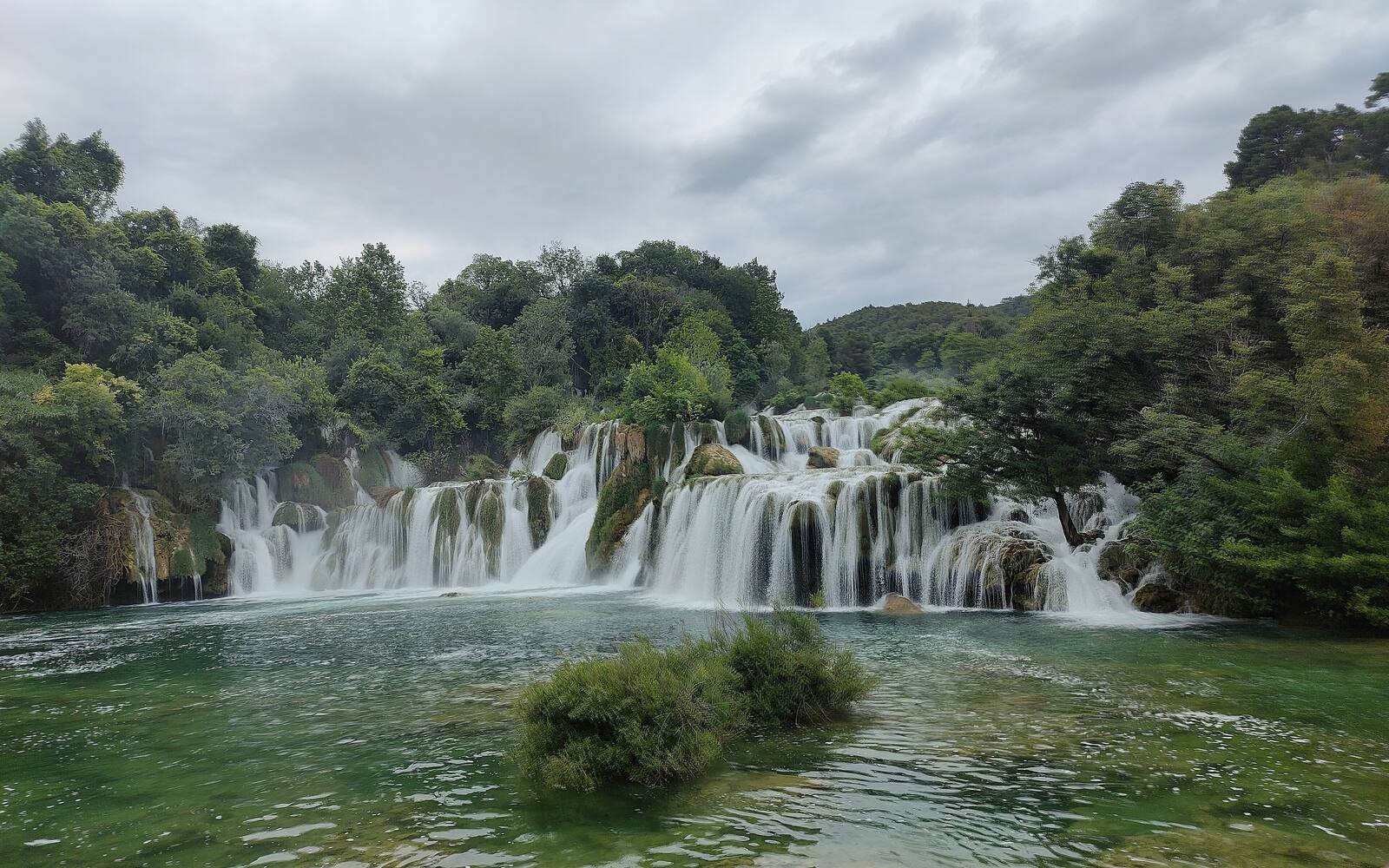 Brede cascade van de waterval Skradinski buk in Nationaal Park Krka tussen groene bomen