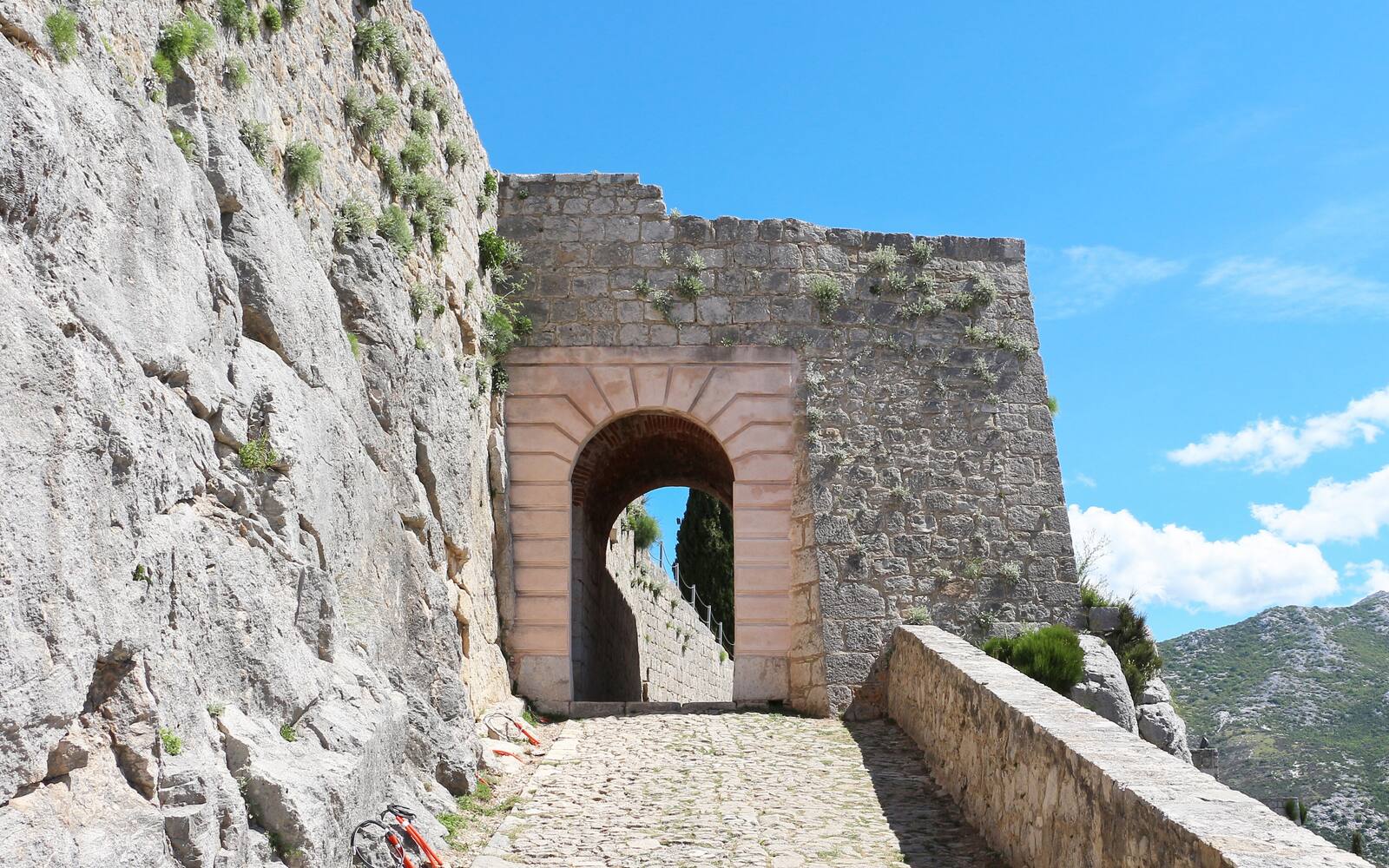 Stenen poort en kasseienpad in de vesting Klis boven Split
