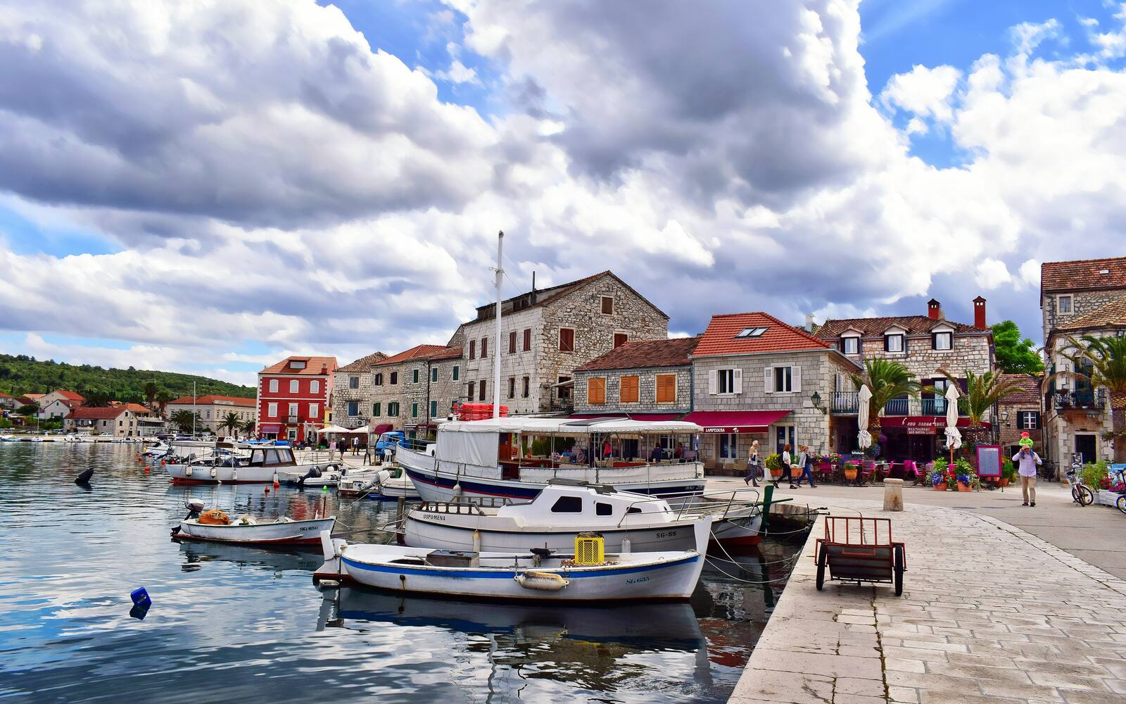 Vissersbootjes in de haven van Stari Grad op Hvar met stenen huizen langs de kade