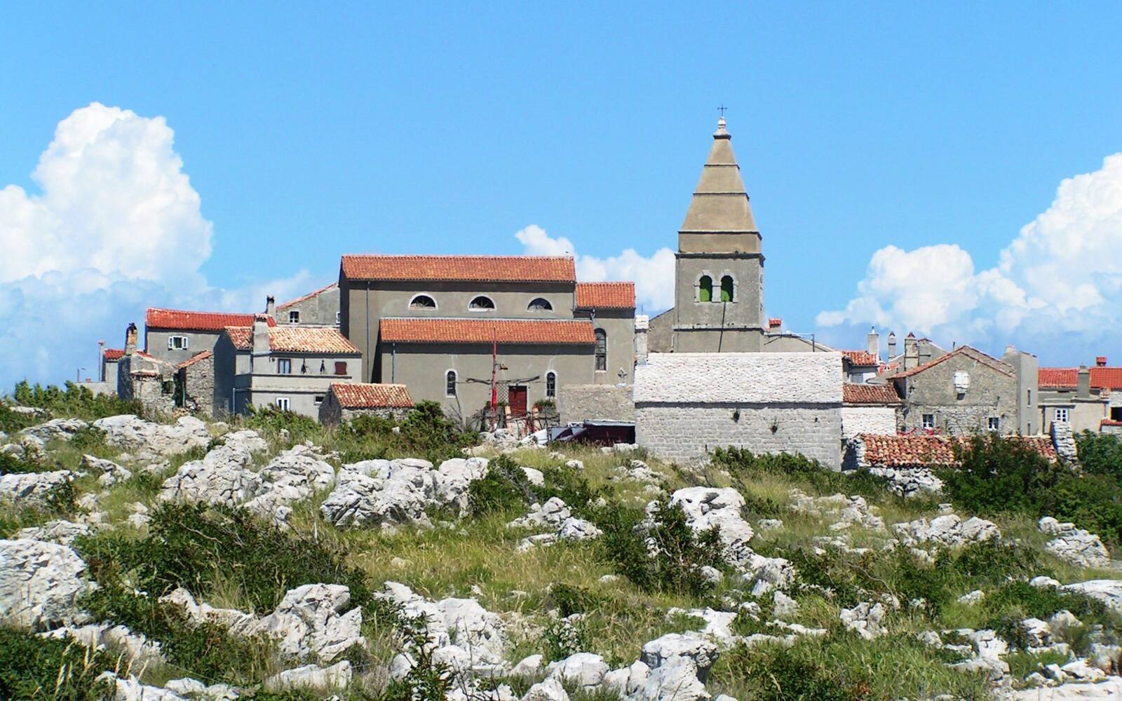 Stenen huizen en de kerktoren van Lubenice op een kale rotsrug op het eiland Cres
