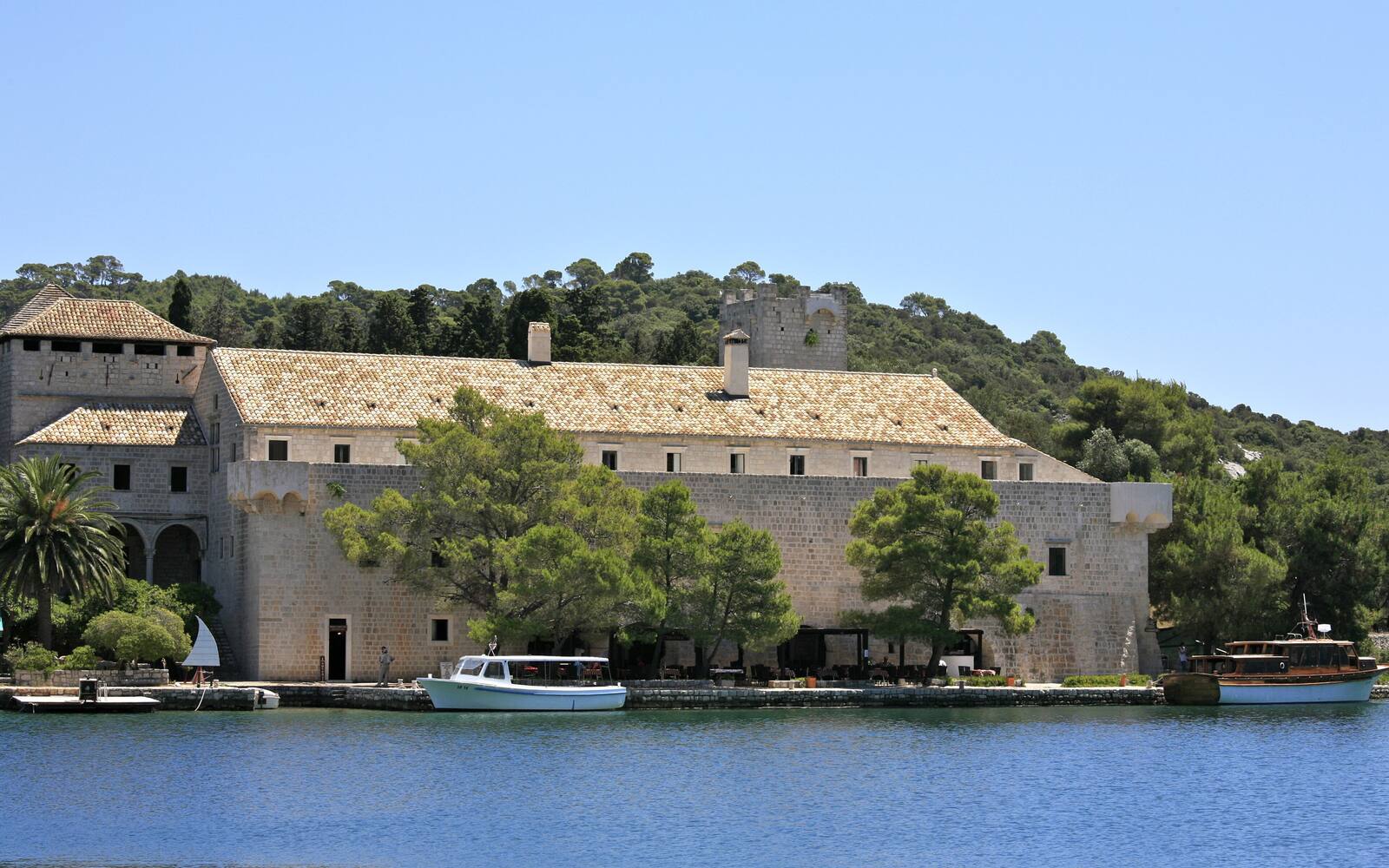 Het benedictijnenklooster op het eilandje Sveta Marija in het grote meer van Mljet, met bootjes aan de kade