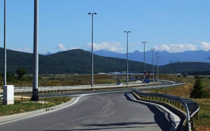 Snelweg A1 bij Gospić met een op- en afrit en de bergen van de Lika op de achtergrond