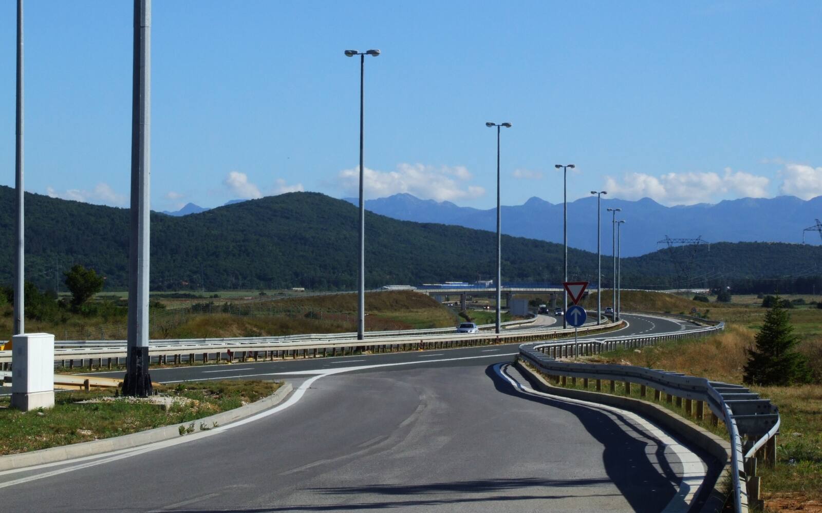 Snelweg A1 bij Gospić met een op- en afrit en de bergen van de Lika op de achtergrond