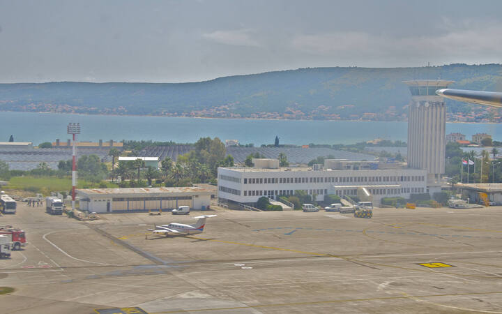 Luchtfoto van luchthaven Split met de terminal en de baai van Kaštela op de achtergrond
