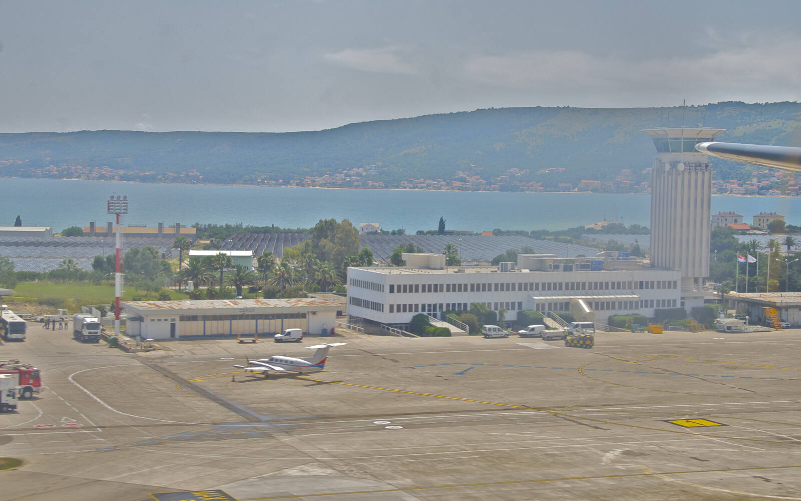Luchtfoto van luchthaven Split met de terminal en de baai van Kaštela op de achtergrond